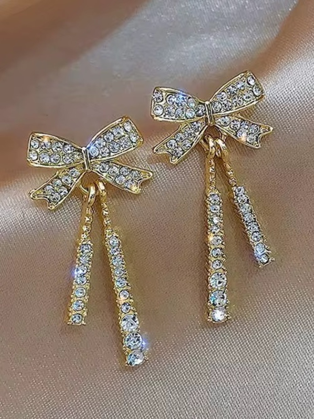 ***Delicate gold-tone bow drop earrings accented with sparkling clear crystals